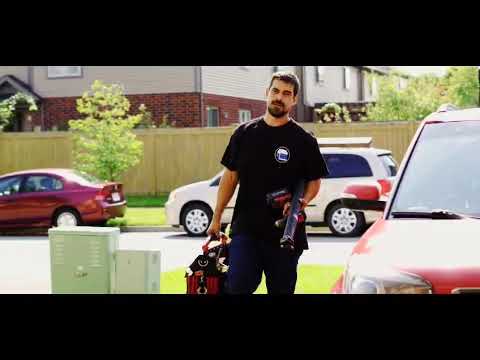 A Garage Doorman technician carrying tools up a residential driveway