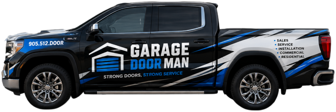The Garage Doorman service truck, a black GMC Sierra wrapped in blue, white and grey, parked inside the shop